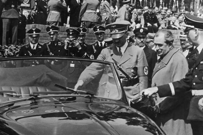 Adolf Hitler inspects the new Volkswagen "people's car" after laying the foundation stone of the new Volkswagen works in 1938. On Hitler's left is the car's designer, Ferdinand "Ferry" Porsche.