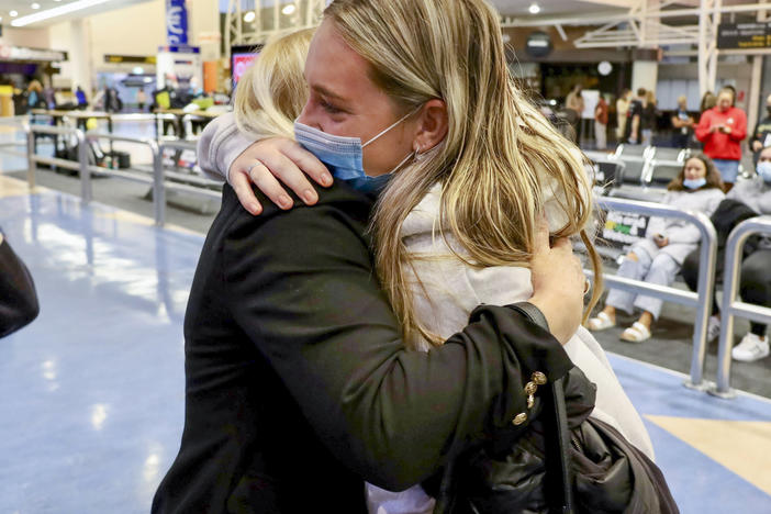 Families embrace after a flight from Los Angeles arrived at Auckland International Airport as New Zealand's border opened for visa-waiver countries Monday, May 2, 2022.