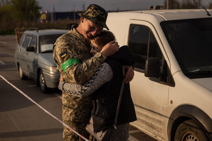 Hryhorii, a member of the Ukrainian military, hugs his wife Oksana, whom he had not seen for nearly a year, after she fled from the Russian-occupied Novomykhailivka village and arrived by car at an evacuation point for people fleeing Mariupol, Melitopol and the surrounding towns under Russian control, on Monday, in Zaporizhzhia, Ukraine.