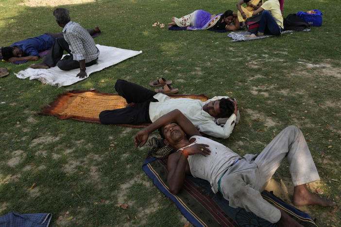 People rest in the shade of a tree on a hot summer afternoon in Lucknow in the central Indian state of Uttar Pradesh, on Thursday. Severe heat wave conditions are sweeping north and western parts of India.
