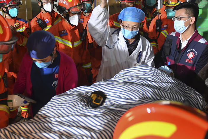 In this photo released by Xinhua News Agency, rescuers transfer a ninth person pulled from the rubble 88 hours after a self-built residential building collapsed in Changsha, central China's Hunan Province, May 3, 2022.