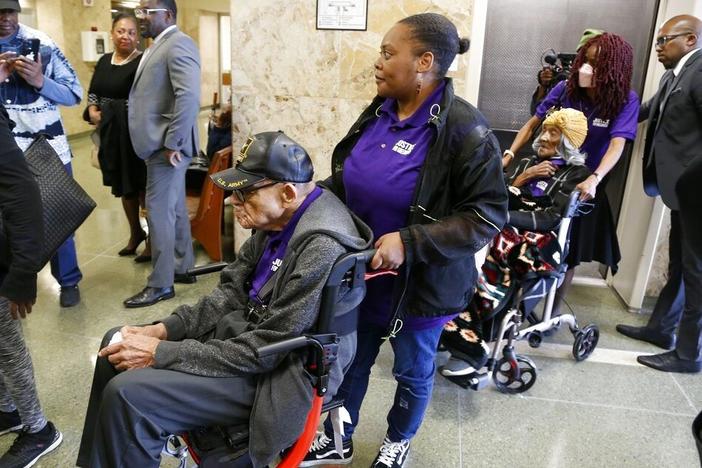 Hughes Van Ellis, 101, foreground left, and Lessie Benningfield Randle, 107, right, survivors of the 1921 Tulsa Race Massacre, outside a courtroom on Monday at the Tulsa County Courthouse, in Tulsa, Okla.
