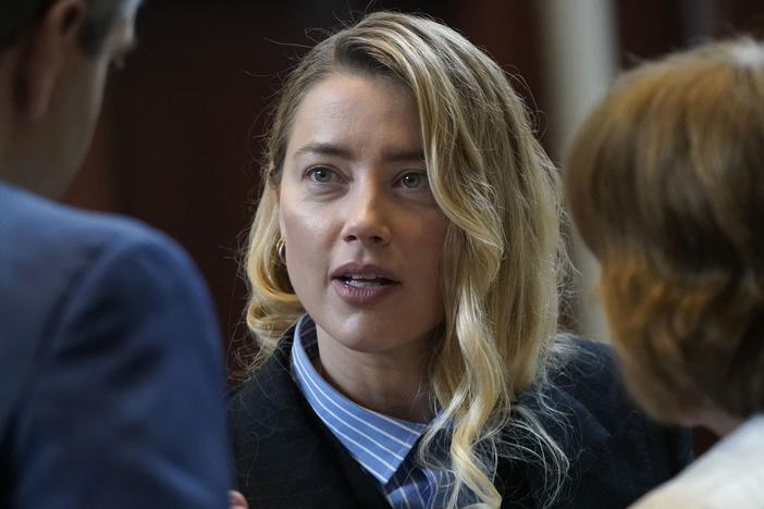 Actress Amber Heard speaks with her legal team Wednesday during a lunch break at the Fairfax Circuit Court in Virginia. Johnny Depp, her ex-husband, is suing her for defamation.