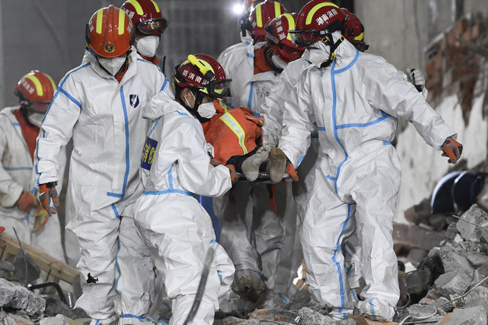 In this photo released by Xinhua News Agency, rescue workers evacuate the 10th survivor pulled alive after being trapped 132 hours from the debris of a self-built residential structure that collapsed in Changsha in central China's Hunan Province on Thursday May 5, 2022.