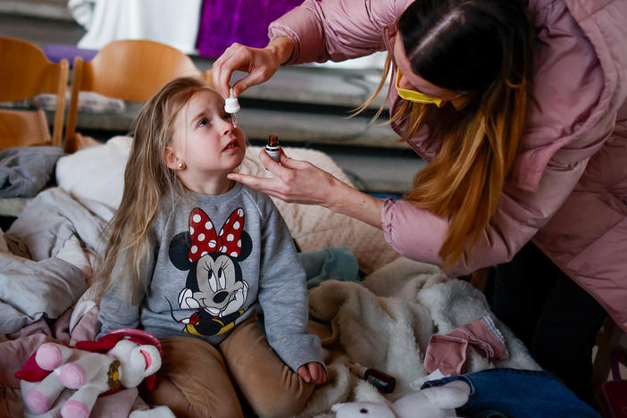 Ukrainian refugee Alina Archipova gives her daughter medication at a temporary shelter in Berlin, Germany, on March 10.