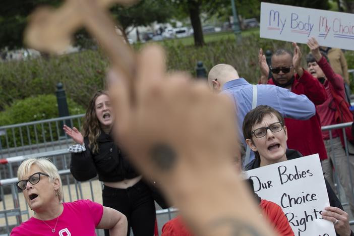 Nate Darnell holds a cross while surrounded by chanting abortion-rights demonstrators outside the U.S. Supreme Court on May 5, 2022 in Washington, D.C.