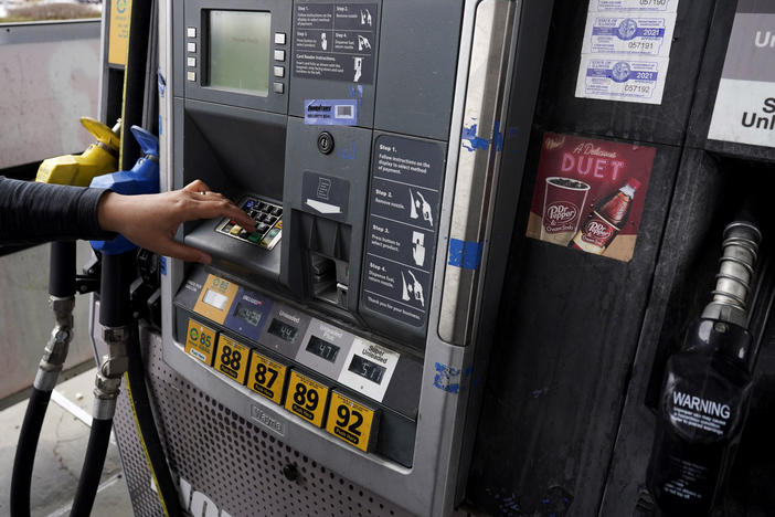 A woman prepares to fuel up at a gas station in East Dundee, Ill., on March 19.