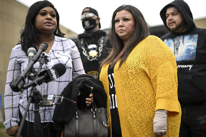 Katie Wright (center) stands beside activist Toshira Garraway and her son, Damik Bryant, during a news conference on Thursday outside a police station in Brooklyn Center, Minn. Katie Wright, the mother of Daunte Wright, said she was injured while she was briefly detained by one of the same department's officers after she stopped to record an arrest of a person during a traffic stop.