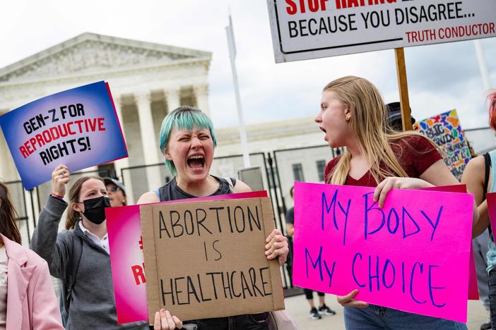 Young people who support access to abortion chant in front of un-scalable fence that stands around the US Supreme Court in Washington, DC, on May 5, 2022.