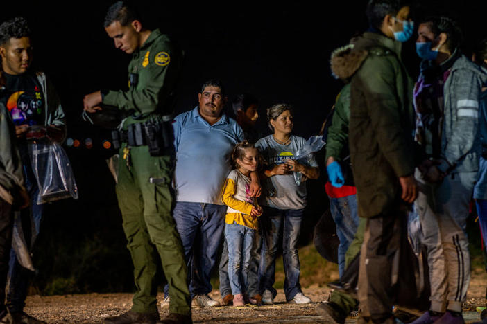 A migrant family stands waiting to be processed on Thursday in Roma, Texas.
