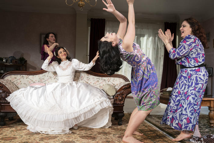 Marjan Neshat (in white dress), Roxanna Hope Radja (behind couch), Nikki Massoud and Artemis Pebdani in <em>Wish You Were Here</em>.