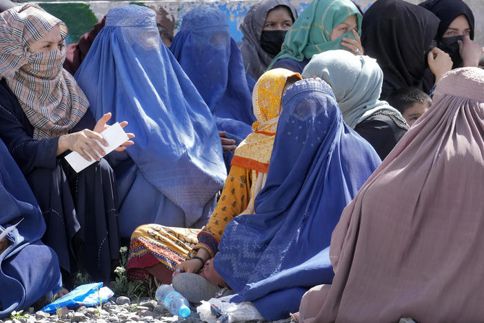Afghan women wait to receive food rations distributed by a Saudi humanitarian aid group, in Kabul on April 25. Afghanistan's Taliban rulers on Saturday ordered all Afghan women to wear head-to-toe clothing in public.