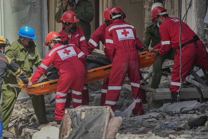 Rescuers recover a body at the site of Friday's deadly explosion that destroyed the five-star Hotel Saratoga, in Havana, Cuba, Saturday, May 7, 2022.