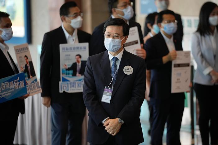 John Lee, former No. 2 official in Hong Kong, and the only candidate for the city's top job, waits for the election committee members outside a polling station for the chief executive election in Hong Kong, Sunday, May 8, 2022.