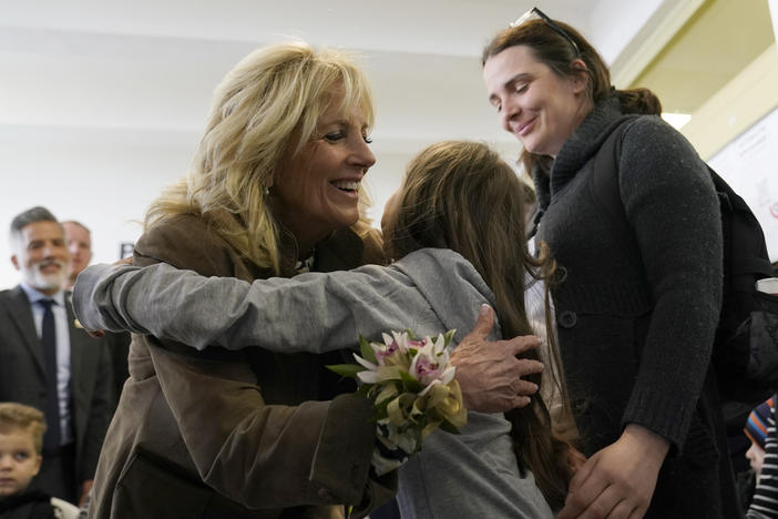 First lady Jill Biden gets a hug from Ukrainian refugee Yulie Kutocha, 7, as her mother Victorie Kutocha, watches at right, during a visit to a city-run refugee center in Kosice, Slovakia, Sunday, May 8, 2022.