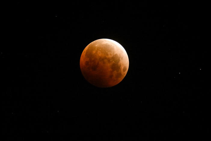 Light shines from a total lunar eclipse over Santa Monica Beach, Calif., in May 2021.