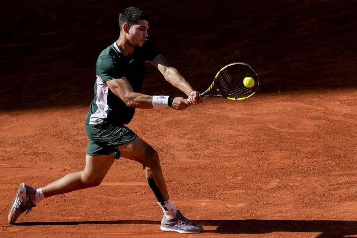 Carlos Alcaraz hits a return to Novak Djokovic on his way to a semifinal win at the Madrid Open tennis tournament. Alcaraz went on to win the tournament, moving him higher in the world's top 10.