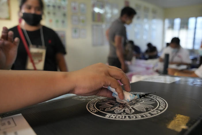 An election worker places a voting receipt inside a box at a polling center Monday in Quezon City, Philippines.