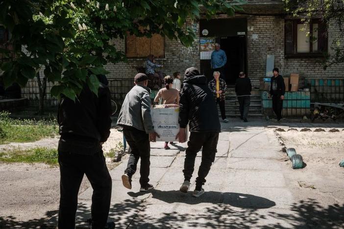 Residents receive food supplies May 7 as volunteers deliver daily from a warehouse of a humanitarian aid distribution center in Severodonetsk, eastern Ukraine