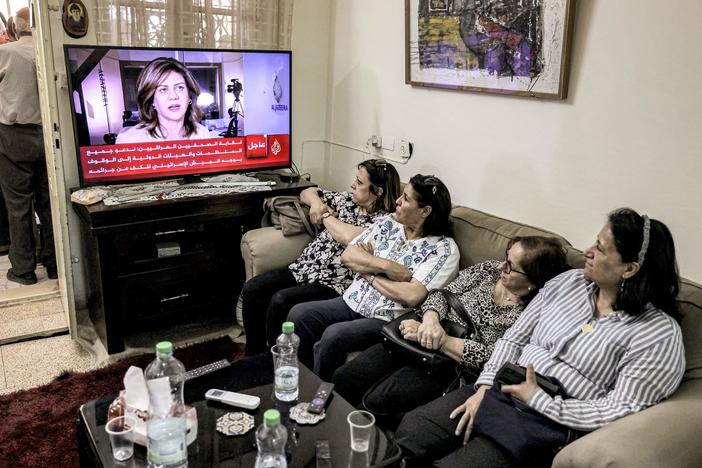 Women watch an Al Jazeera obituary report on TV at the family home of Al Jazeera journalist Shireen Abu Akleh in the Palestinian neighborhood of Beit Hanina in Israeli-occupied east Jerusalem on Wednesday, after she was killed as she covered an Israeli army raid on Jenin refugee camp in the occupied West Bank.