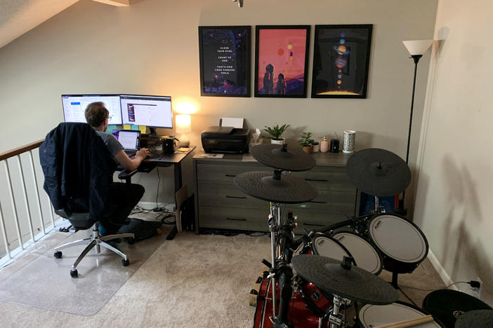 Kevin Dole works from home next to his wife's bureau and near his drum set in the couple's small two-bedroom condo in Nashville, Tennessee.