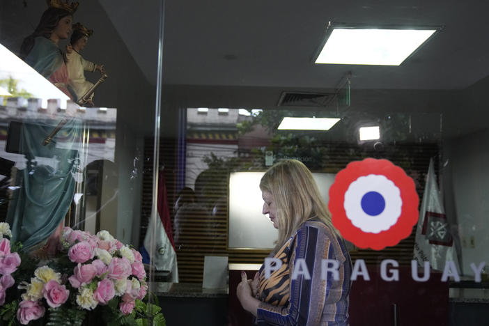 Paraguay Attorney General Sandra Quiñonez prays to a Virgin Mary statue at the entrance of her office in Asuncion, Paraguay, after she found out about the killing of Paraguayan prosecutor Marcelo Pecci on Tuesday.