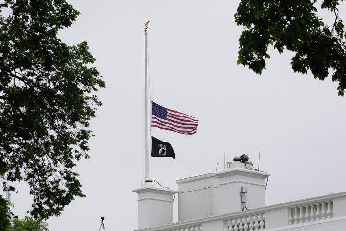 The American flag flies at half-staff at the White House on Thursday as President Biden commemorates 1 million American lives lost due to COVID-19.