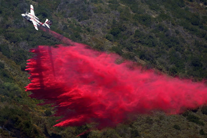 A plane drops fire retardant onto the fire on Thursday in Laguna Niguel, Calif.