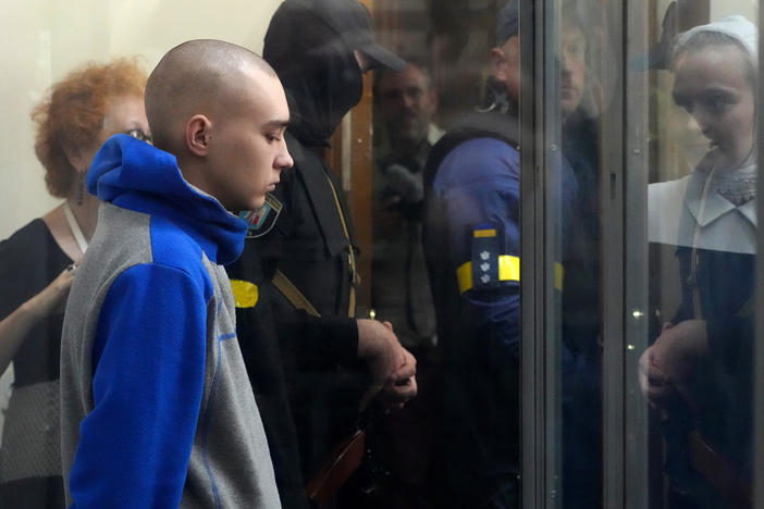 Russian army Sgt. Vadim Shishimarin, 21, is seen behind a glass during a court hearing in Kyiv, Ukraine, on Friday. He is accused of killing a Ukrainian civilian. The first war crimes trial since Moscow's invasion of its neighbor opened Friday.