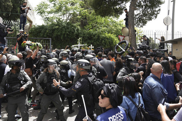 Israeli police in riot gear confront mourners and the journalists on Friday covering the transfer from the hospital of slain Al Jazeera veteran journalist Shireen Abu Akleh to her final resting place in east Jerusalem. Abu Akleh, a Palestinian-American reporter, was shot dead Wednesday during an Israeli military raid in the West Bank town of Jenin.