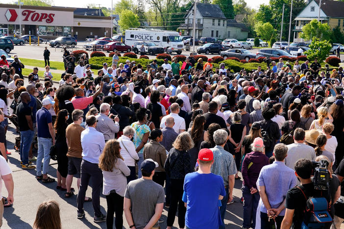 People gather outside the scene of a shooting at a supermarket in Buffalo, N.Y., Sunday, May 15, 2022.