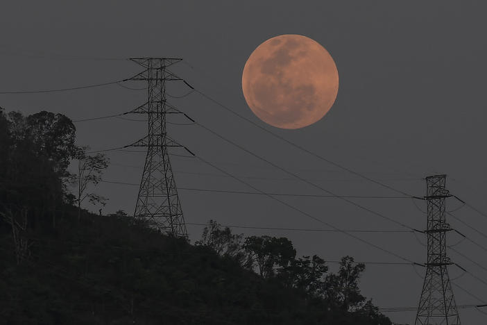 A full moon rises behind the high voltage towers of the El Avila in Caracas, Venezuela, Sunday, May 15. People in the Americas, Europe and Africa had a chance to see the total lunar eclipse that began Sunday night.