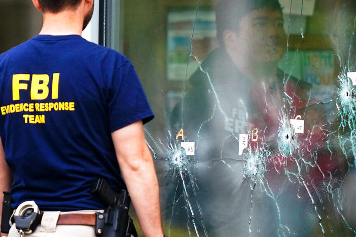 Investigators work the scene of a shooting at a supermarket, in Buffalo, N.Y., on Monday.