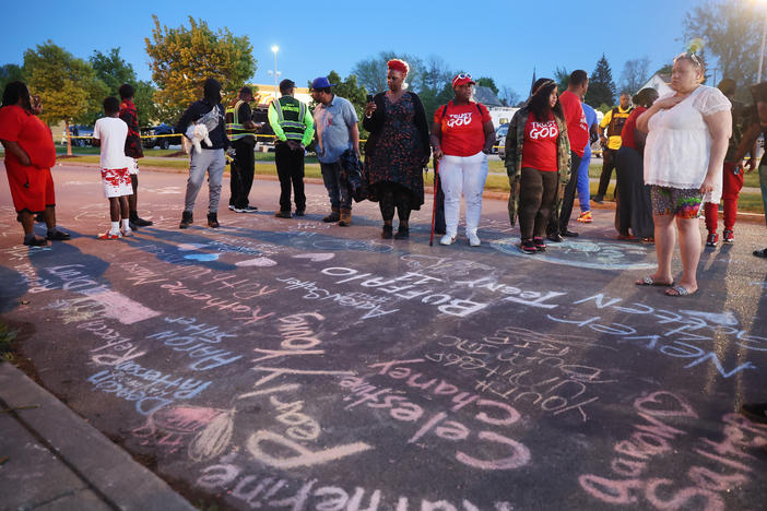 The names of the victims and messages of healing written in chalk at a makeshift memorial outside of the Tops supermarket in Buffalo, N.Y., on Sunday, one day after a gunman killed 10 people and injured 3 others.