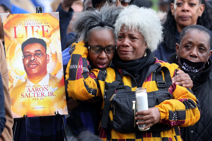 People participate in a vigil to honor the 10 people killed in Saturday's shooting at Tops market in Buffalo, New York.
