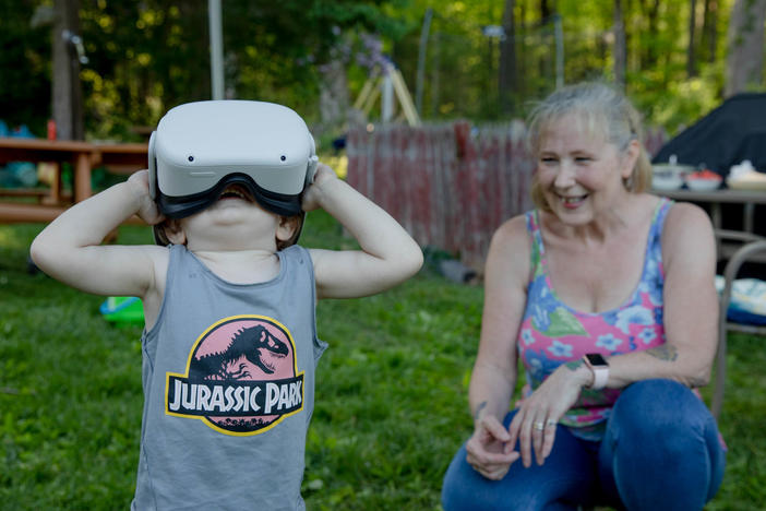 Linda Munson's youngest grandson, Daniel Gomez, 2, tries on an Oculus headset in her yard in Berlin, Conn. Playing different virtual reality games has become her family's regular Sunday activity, Munson said.