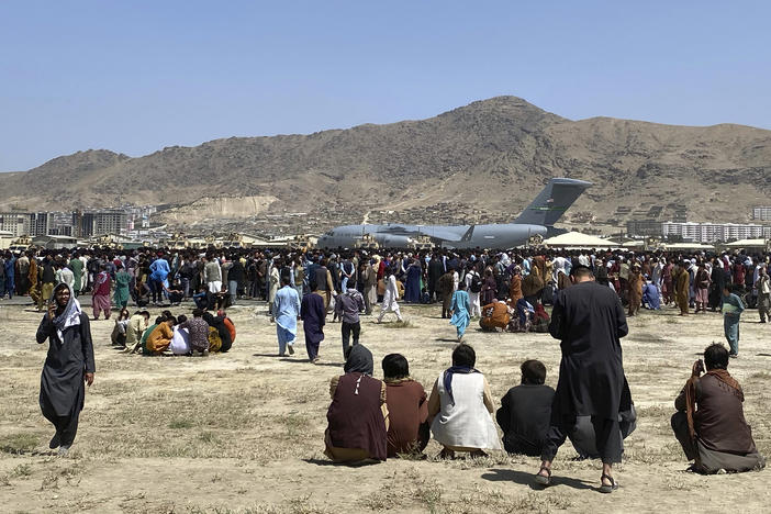 Hundreds of people gather near a U.S. Air Force C-17 transport plane at the perimeter of the international airport in Kabul, Afghanistan, on Aug. 16, 2021. SIGAR, released its interim report Wednesday detailing why Afghanistan's government and military collapsed immediately after the U.S. withdrawal.