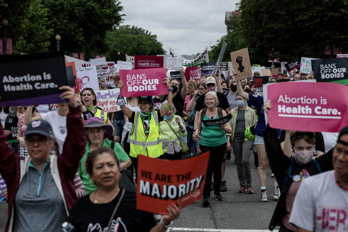 Pro-abortion rights demonstrators march in Washington, D.C., on May 14. While most U.S. adults favor some restrictions on abortion, according to our new poll, most also say they do not support overturning <em>Roe v. Wade</em>.