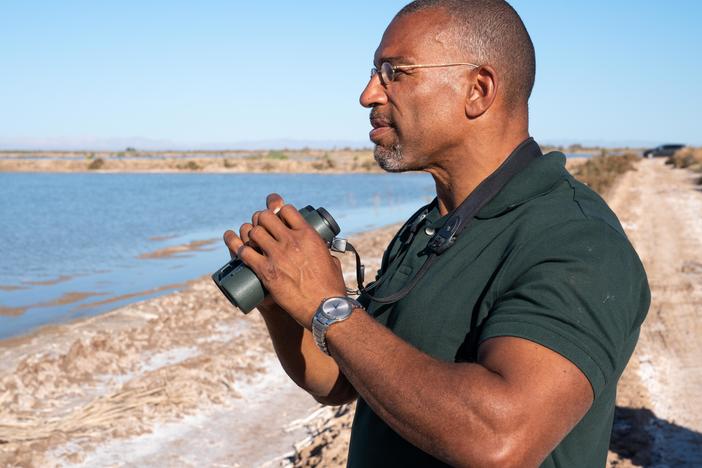 Christian Cooper watches distant shorebirds at the Sonny Bono Salton Sea National Wildlife Refuge in California. The National Geographic channel has announced that Cooper will host a series called <em>Extraordinary Birder</em>. Cooper was in the spotlight after a woman in New York City's Central Park called the police and falsely accused him of threatening her in May 2020.