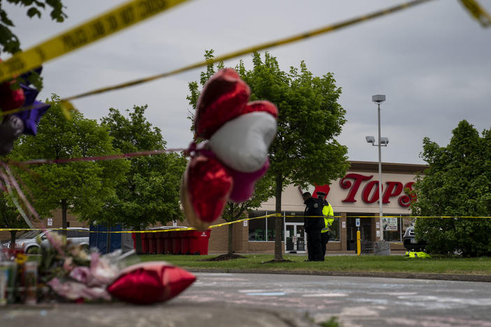 People gather at the scene of a mass shooting at Tops Friendly Market at Jefferson Avenue and Riley Street on Monday, May 16, 2022 in Buffalo, NY.
