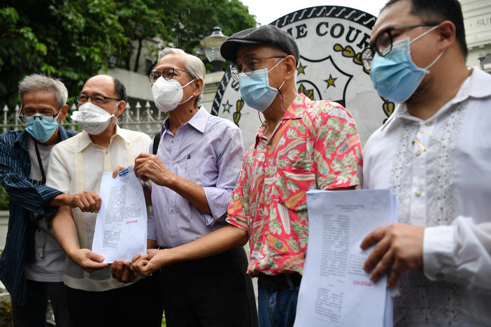 Martial law victims including former lawmaker Satur Ocampo (third from left) and their lawyers headed by Howard Calleja (second from left), show documents after filing a petition with the supreme Court in Manila on Wednesday seeking the disqualification of presumptive president Ferdinand Marcos Jr.