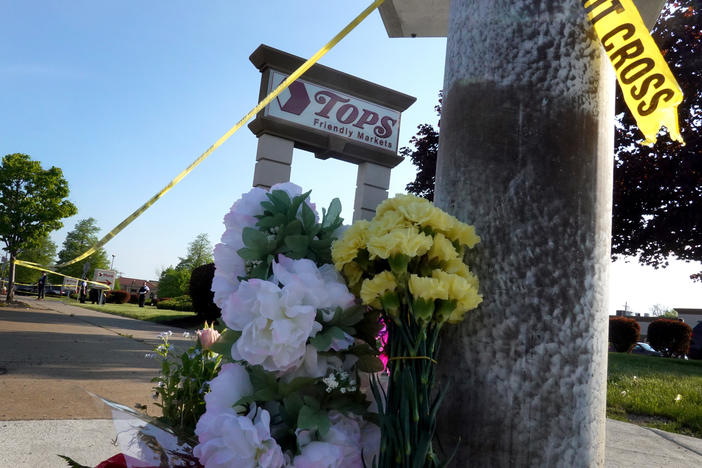 Flowers are left at a makeshift memorial outside of the Tops market on May 15 in Buffalo, N.Y.