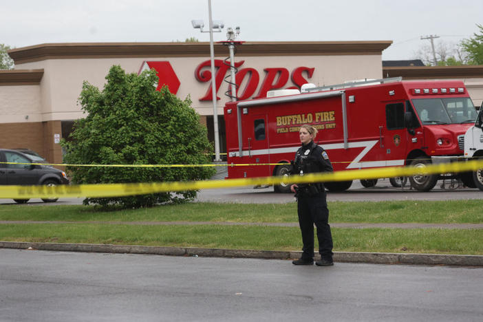 Police continue the investigation at the Tops supermarket May 18 in the Cold Spring neighborhood of Buffalo, N.Y. A gunman opened fire at the store on Saturday, killing 10 people and wounding three others. Police say it's being investigated as a racially motivated hate crime.