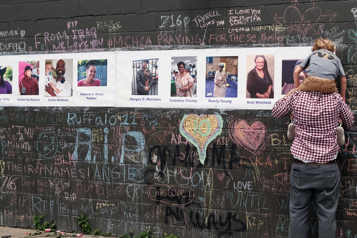 Photos of people killed in the mass shooting at Tops grocery store in Buffalo, N.Y., are part of a memorial near the store.