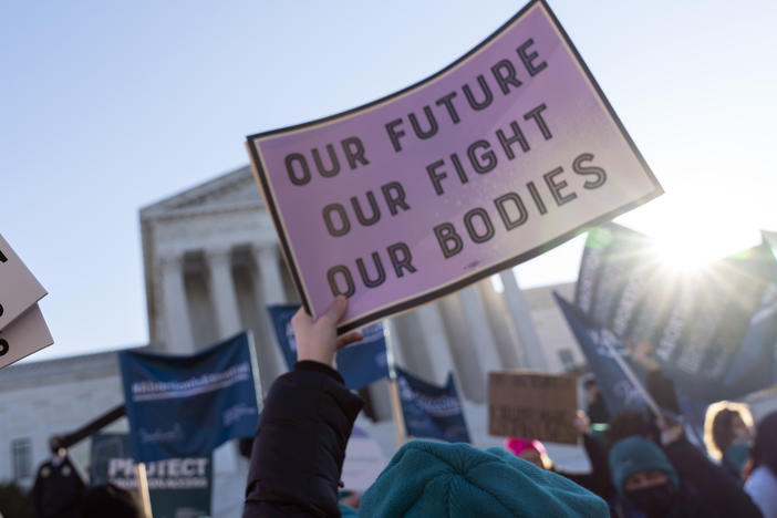 Abortion-rights advocates demonstrate in front of the Supreme Court last December as it heard a case that could strike down the constitutional right to abortion. Economists say decades of research show that doing so would limit women's economic prospects.