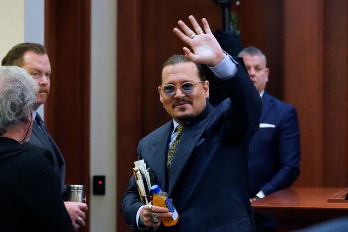 Actor Johnny Depp waves to the gallery as he leaves for a break Monday during his defamation trial in Fairfax, Va. against his ex-wife, Amber Heard.