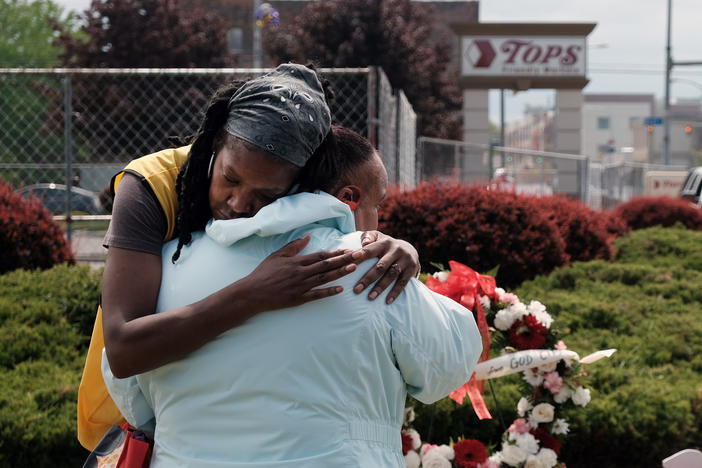 People embrace near a memorial for the shooting victims outside of Tops grocery store on May 20, 2022 in Buffalo, New York.