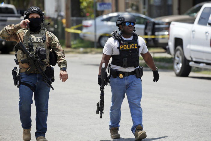 Police walk near Robb Elementary School in Uvalde, Texas, following Tuesday's mass shooting there.