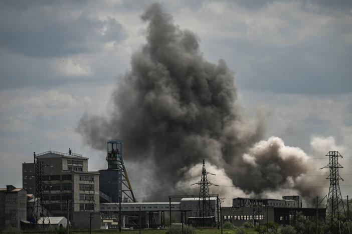 Smoke and debris ascend after a strike at a factory in the city of Soledar, in eastern Ukraine's Donbas region, on Tuesday. At the three-month point since Russia launched its large-scale invasion of Ukraine, fighting has been intensifying in the east.