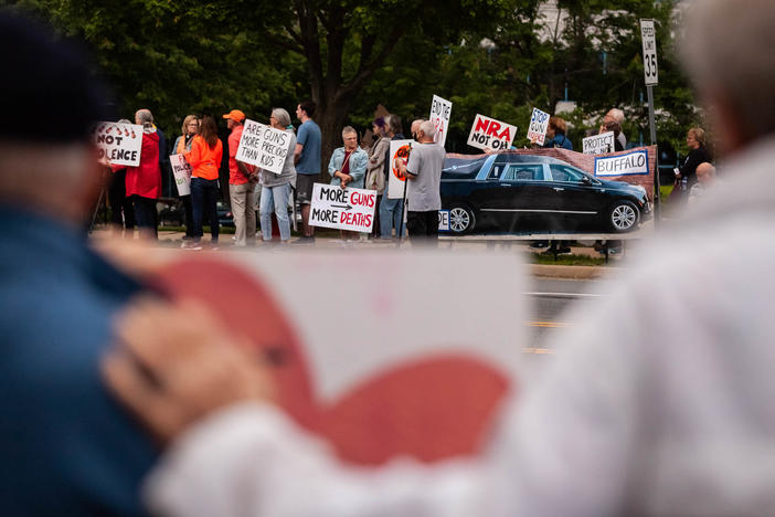 Demonstrators attend a candlelight vigil Wednesday in Fairfax, Va., for the victims of the Uvalde and Buffalo mass shootings.